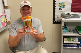 An image of Kevin Holle holding a box of pencils.