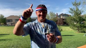 An image of Kevin Holle holding his trophy after winning the cornhole game.